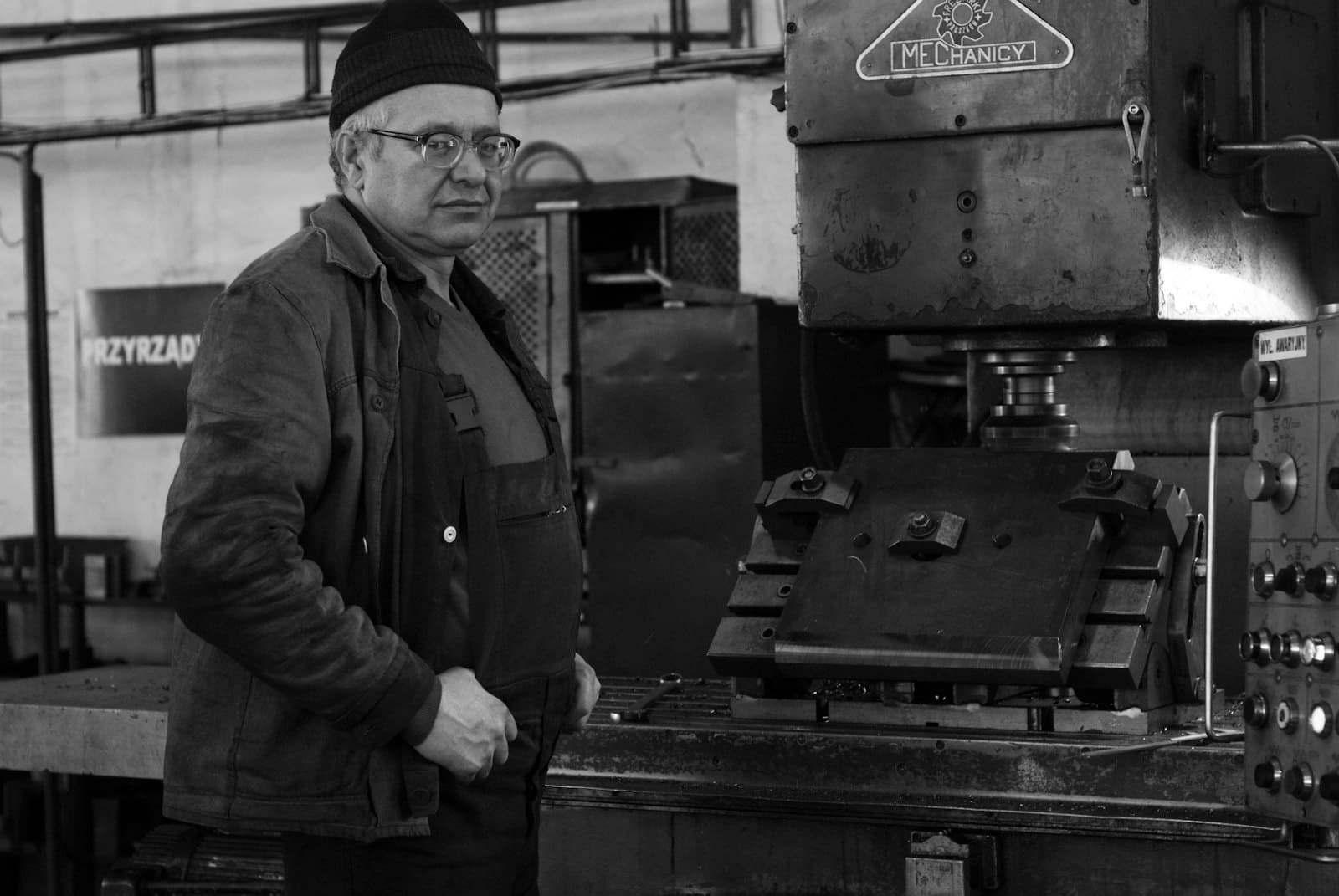 Un machiniste expérimenté devant sa machine, en noir et blanc